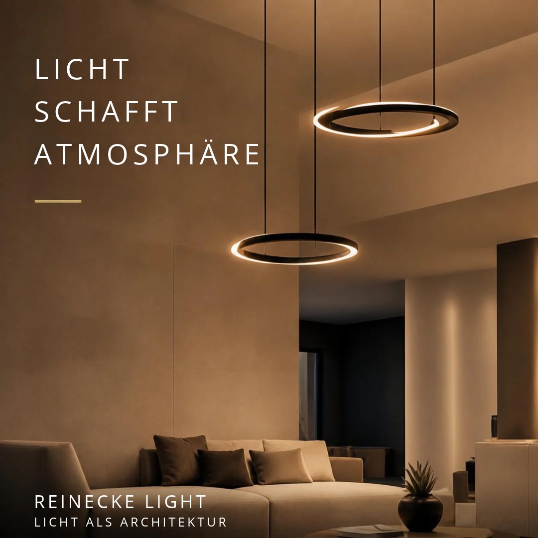 Eleganter Wohnraum mit ringförmigen Designer-Pendelleuchten, warmem Licht und harmonisch abgestimmter Architekturbeleuchtung. Elegant living space with circular designer pendant lights, warm lighting and harmoniously integrated architectural illumination.